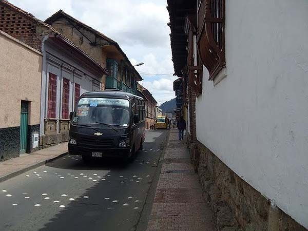 busetas circulando por una calle del centro de Bogotá