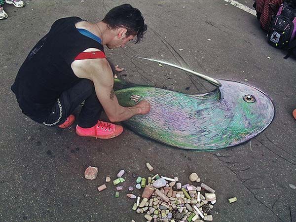 artista urbano pintando en la ciclovía de bogotá